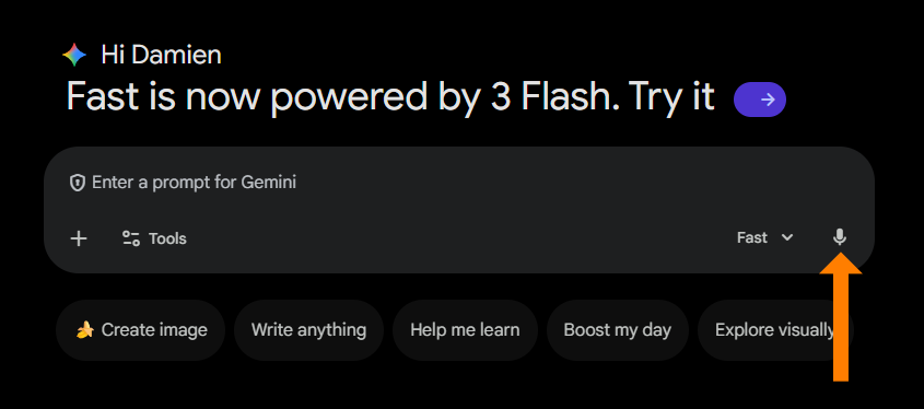 A screenshot of the Gemini AI user interface, identical to the previous image, with the addition of a prominent orange arrow pointing directly to the microphone icon located at the far right of the text input box. The arrow highlights the voice input feature within the interface.